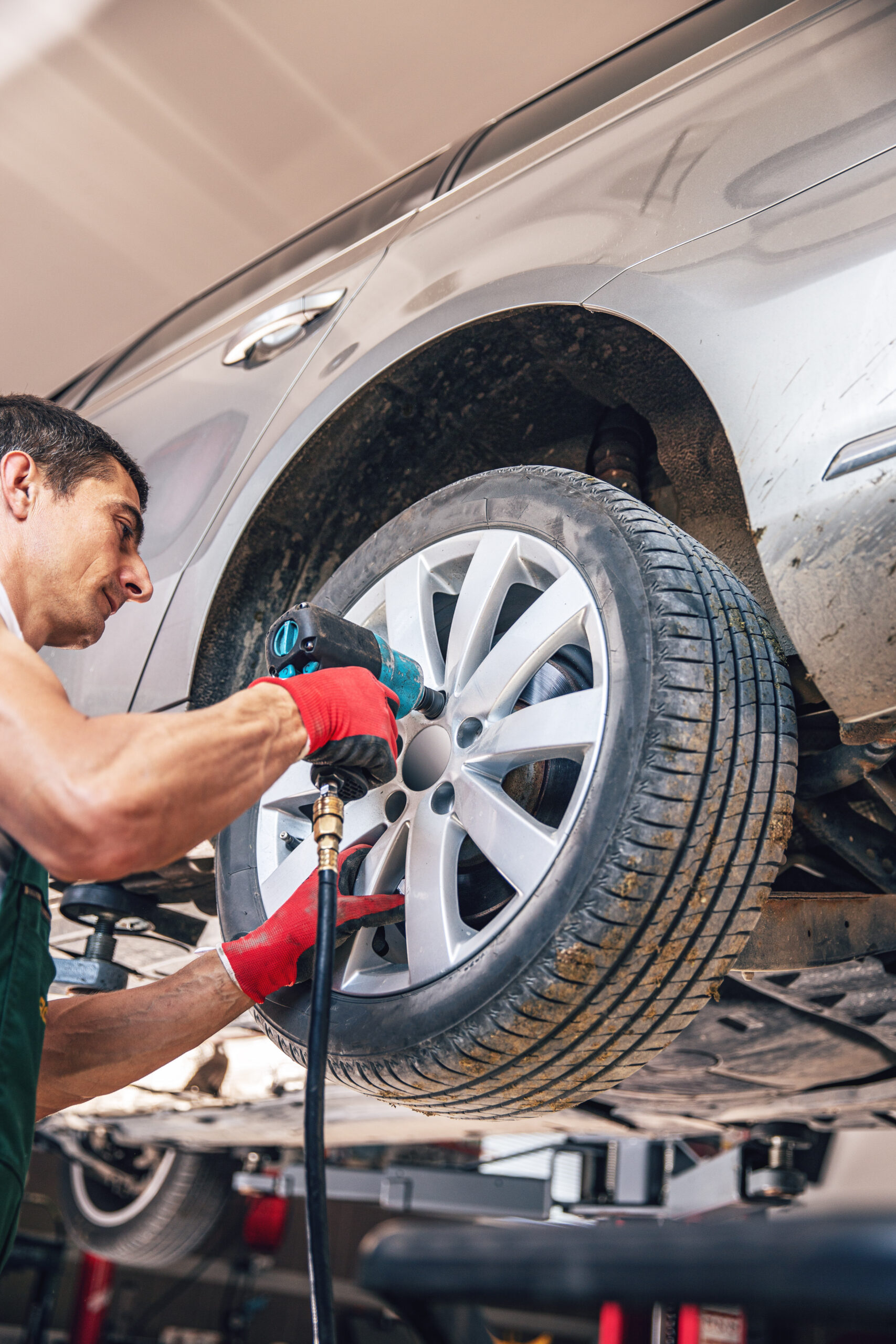 Car mechanic remove or install wheel nut in his garage